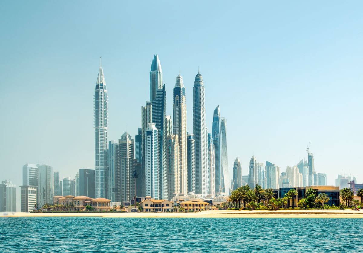 Moderní panorama Dubaje s vysokými mrakodrapy a pobřežím Perského zálivu v popředí.