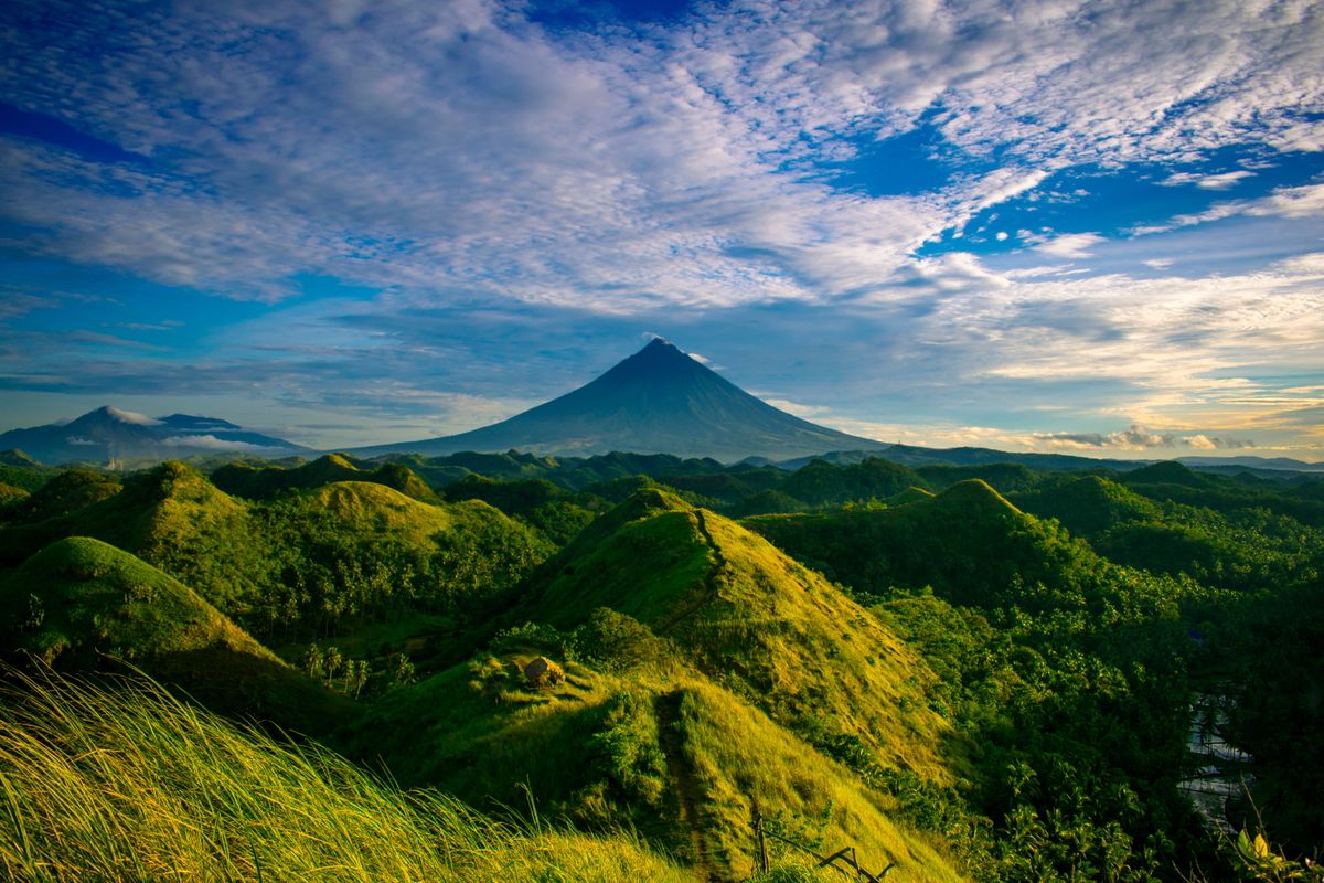 Zelené kopce s&nbsp;výhledem na majestátní vulkán Mayon na Filipínách.