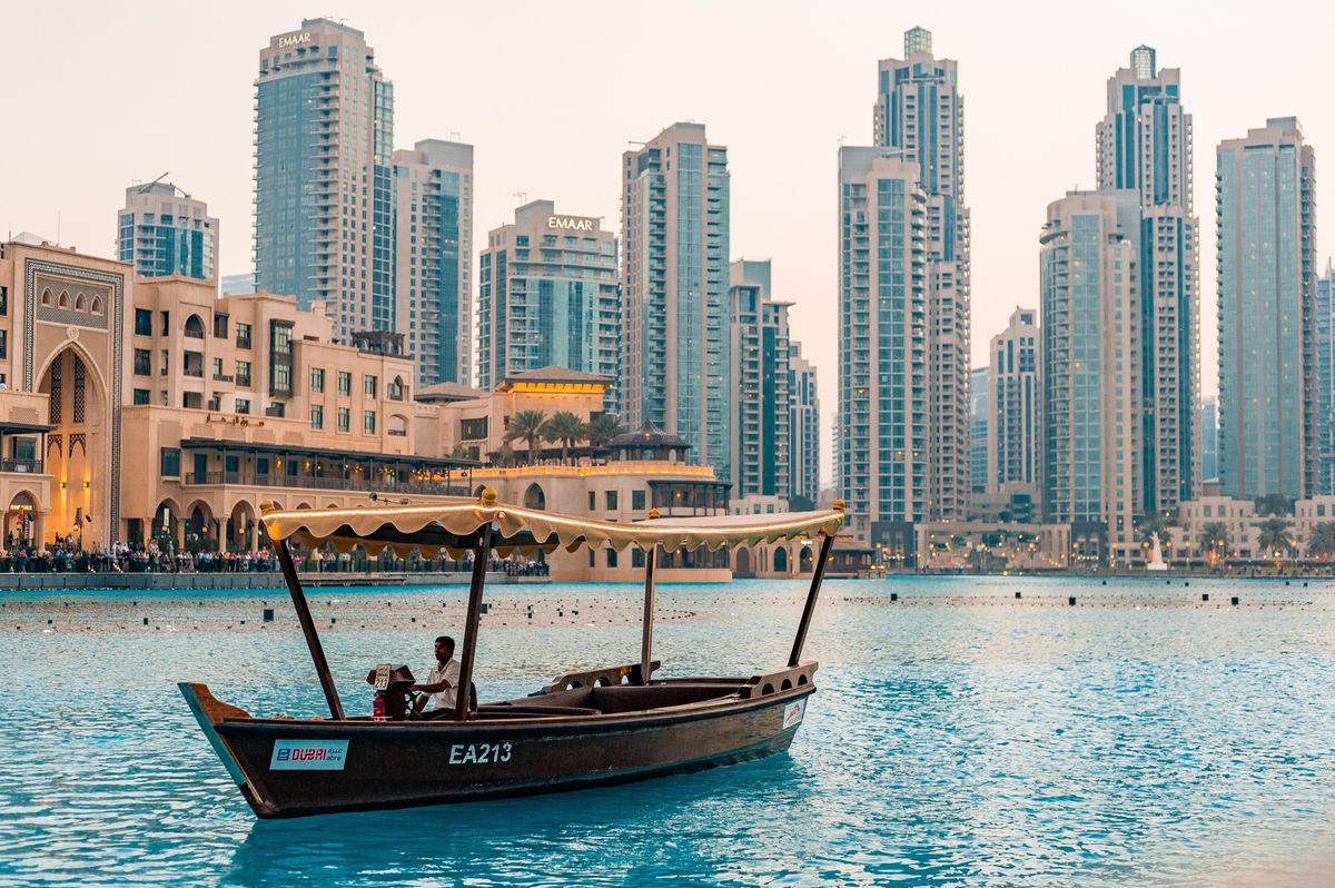 Vodní taxi proplouvá kolem moderních mrakodrapů v centru Dubaje.