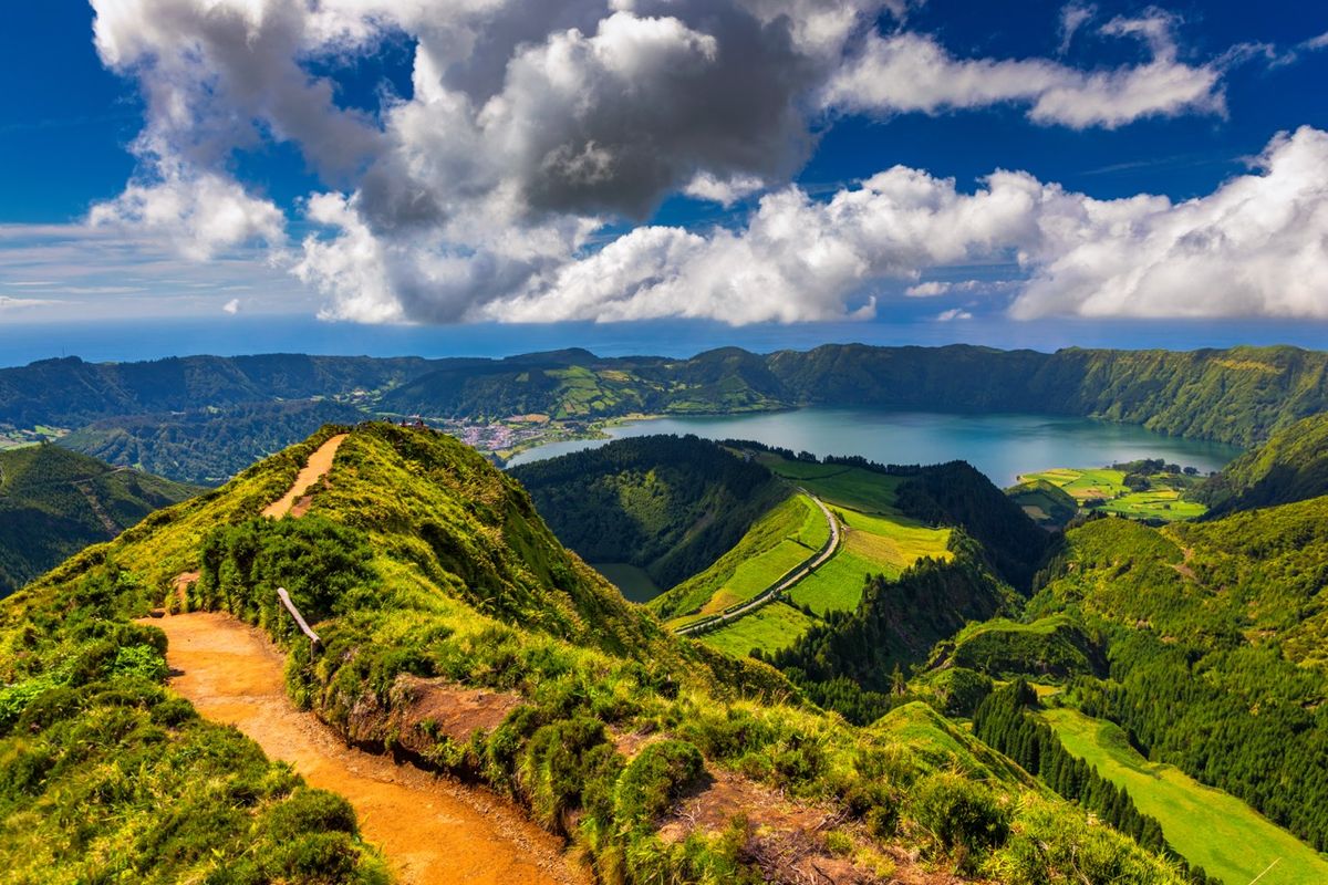 Pohled na zelené kopce a&nbsp;kráterové jezero Sete Cidades na ostrově São Miguel na Azorských ostrovech s&nbsp;dramatickými mraky na obloze.