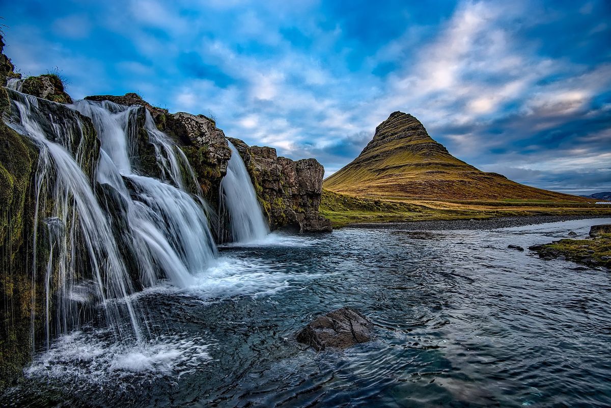 Vodopád Kirkjufellsfoss s ikonickou horou Kirkjufell v pozadí na západním pobřeží Islandu.