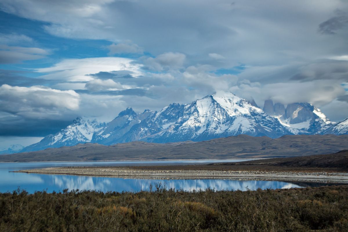 Zasněžené vrcholky hor v&nbsp;národním parku Torres del Paine se odráží na hladině jezerní krajiny v&nbsp;Patagonii.