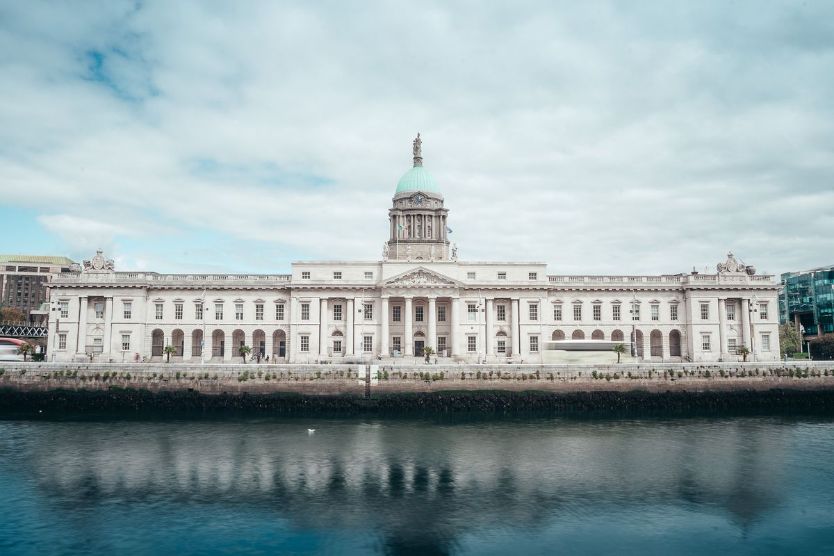 Custom House v&nbsp;Dublinu, elegantní neoklasicistní budova se odráží na klidné hladině řeky Liffey.