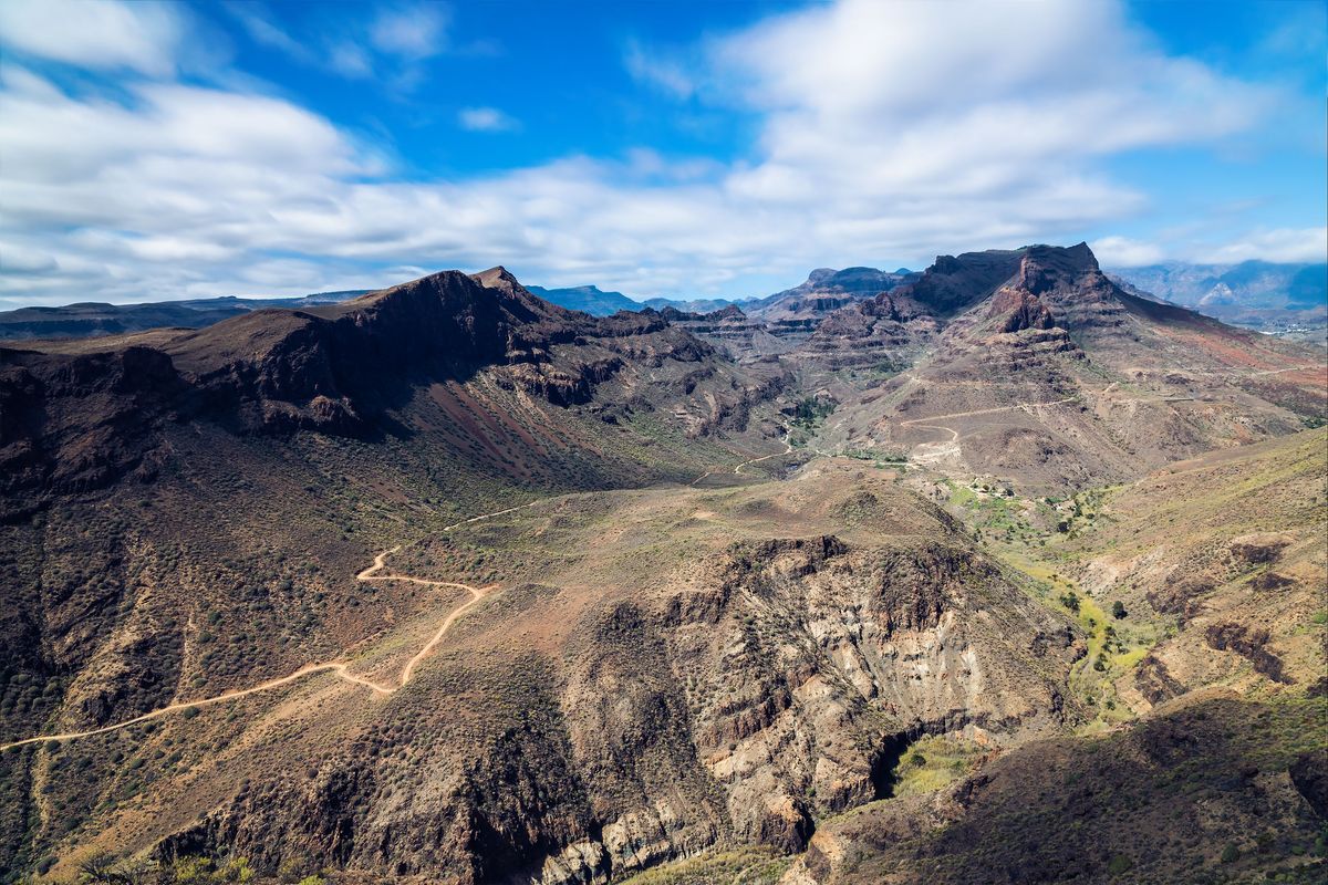 Horská krajina s dramatickými útesy na ostrově Gran Canaria za slunečného dne.