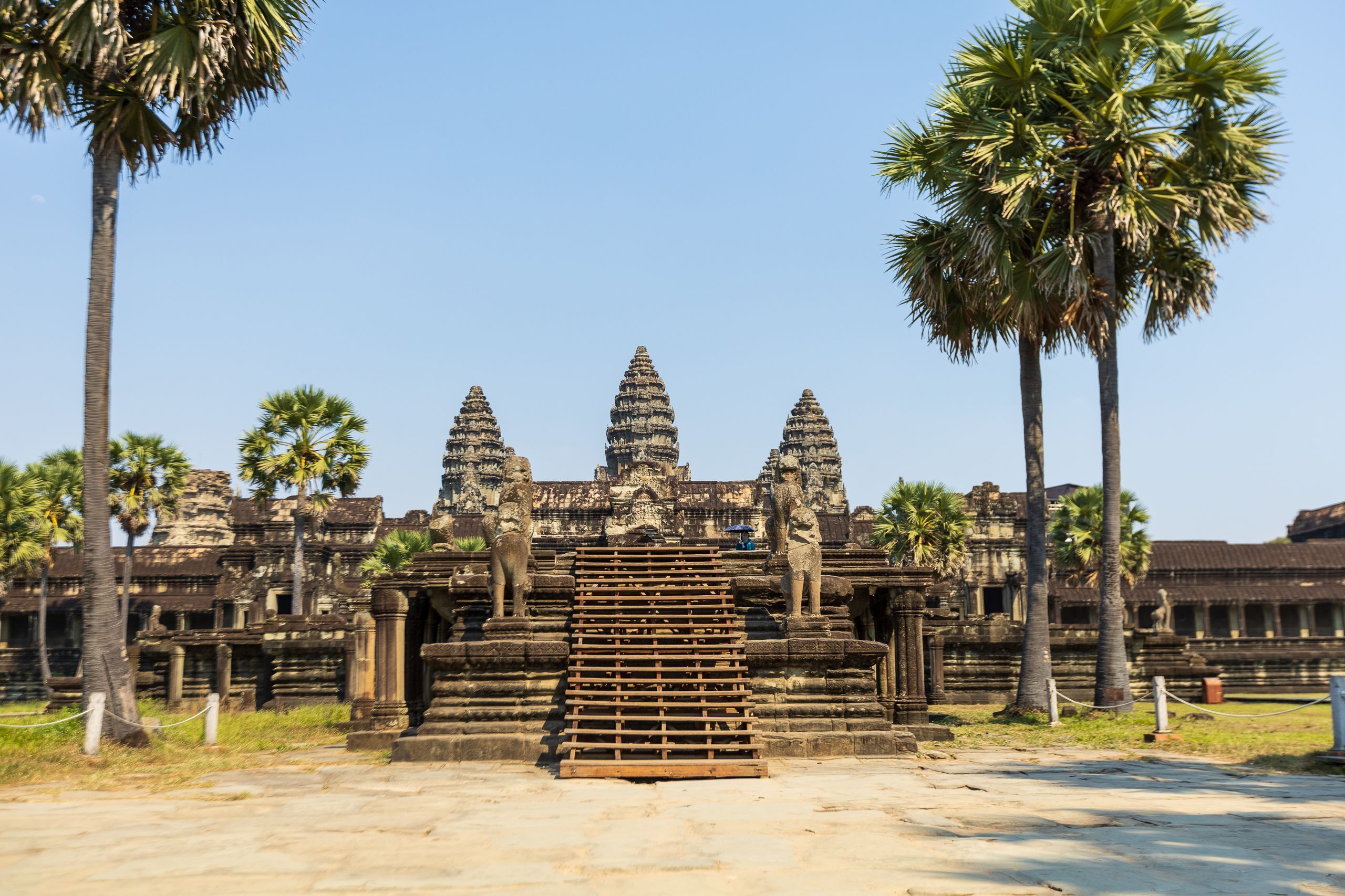 Chrámový komplex Angkor Wat v&nbsp;Kambodži s&nbsp;majestátními věžemi a&nbsp;palmami v&nbsp;popředí.