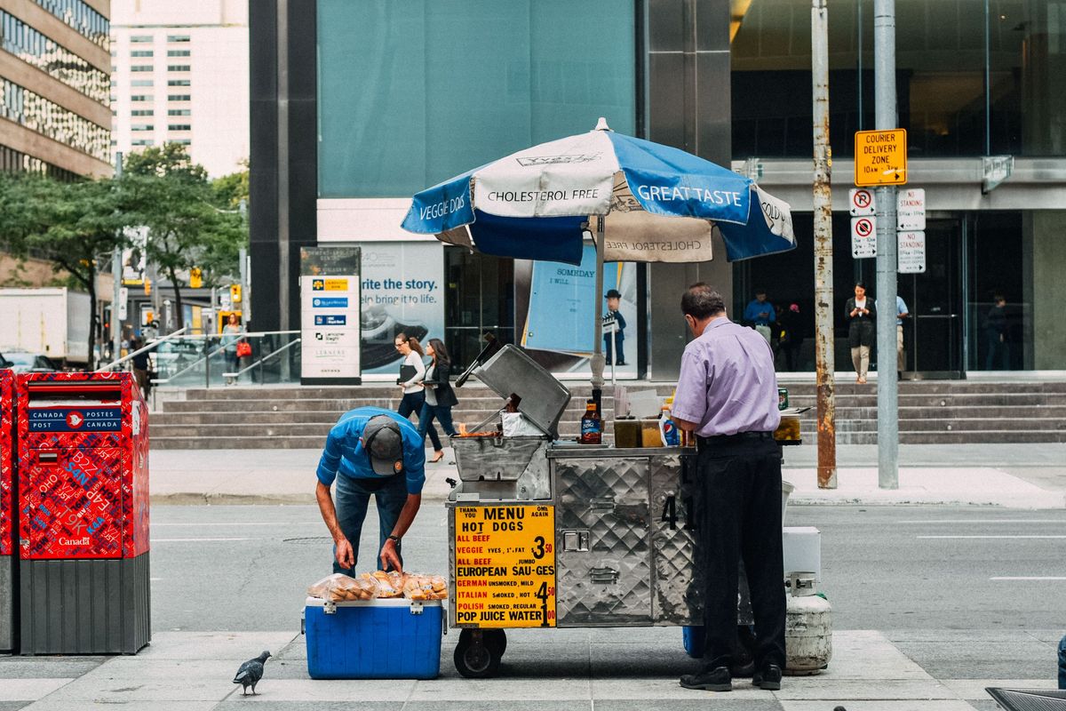 Ulice s&nbsp;občerstvovacím stánkem na hotdogy v&nbsp;kanadském městě, poblíž poštovní schránky Canada Post na rušné městské třídě.