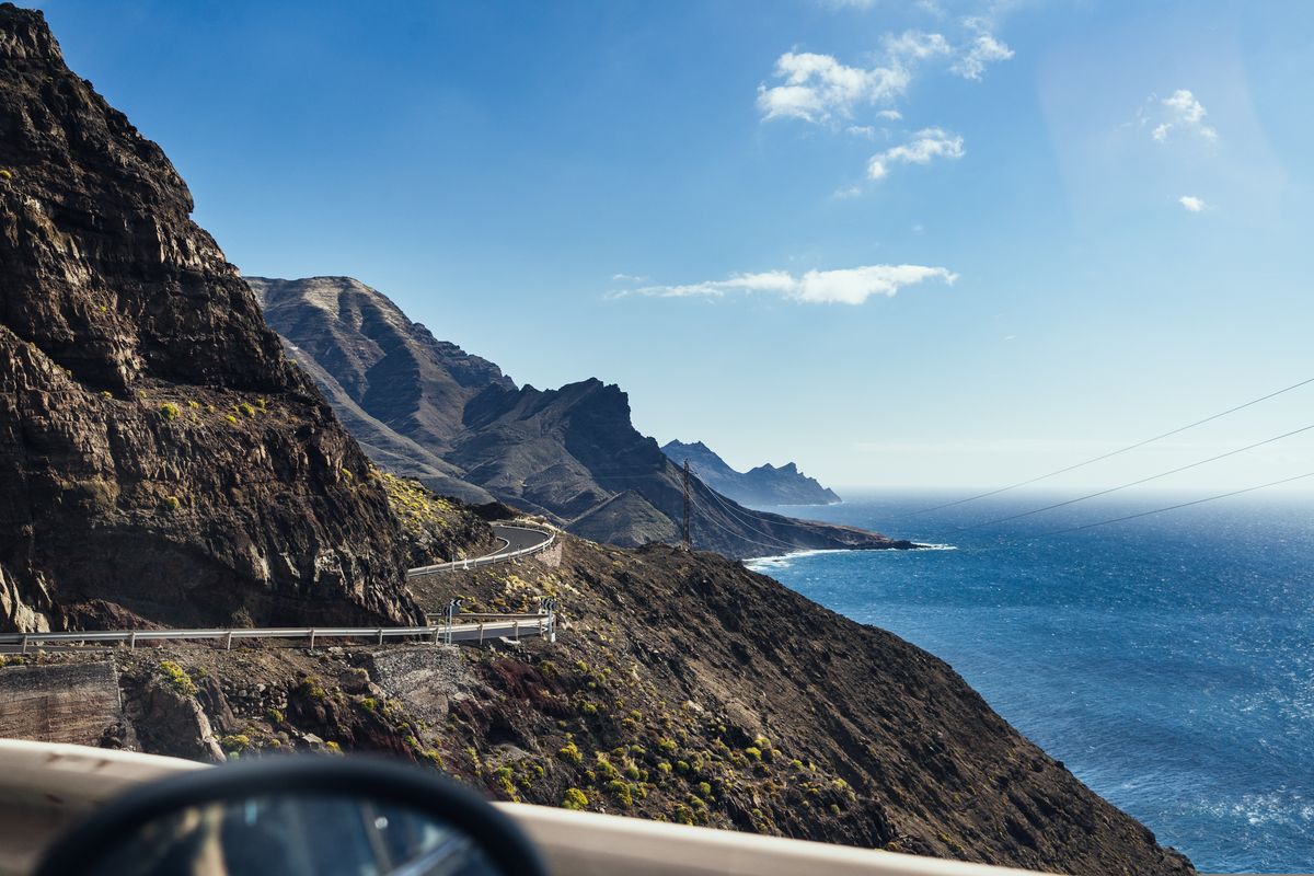 Křivolaká silnice se klikatí podél dramatických útesů ostrova Gran Canaria, přičemž se po pravé straně rozprostírá Atlantský oceán.