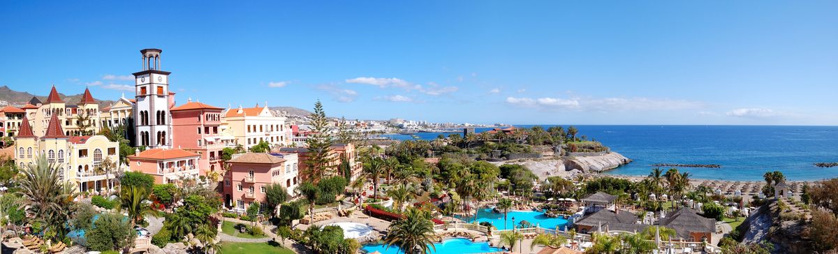 Luxusní hotelový areál s palmami a bazény u pobřeží Atlantského oceánu na ostrově Tenerife.