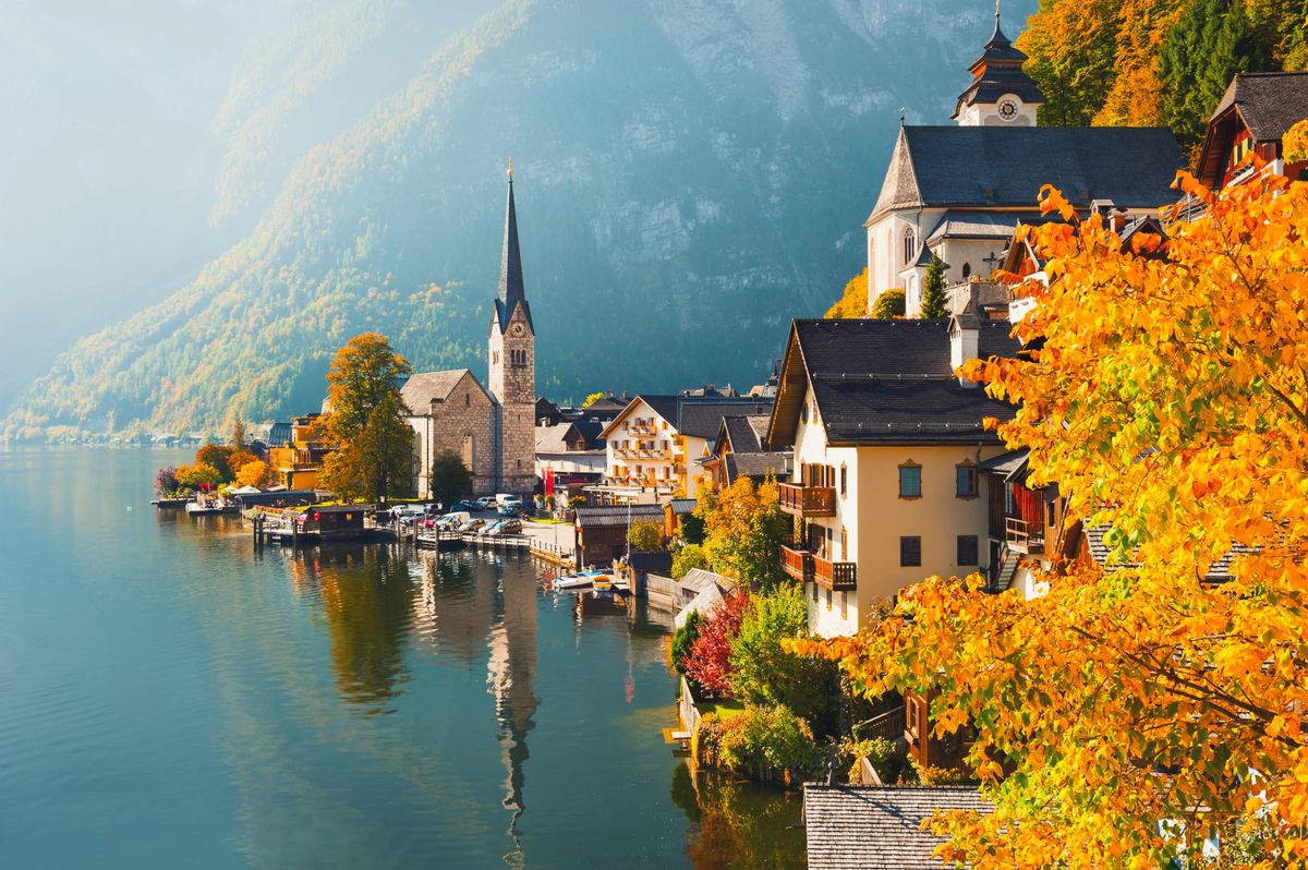 Malebné městečko u jezera obklopené horami se starobylým kostelem a tradičními rakouskými domy v obci Hallstatt na podzim.
