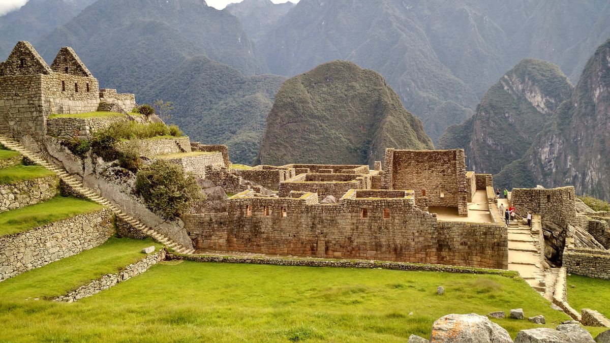 Incké ruiny Machu Picchu se rozprostírají uprostřed andského pohoří, obklopené bohatou vegetací a horskými vrcholy.