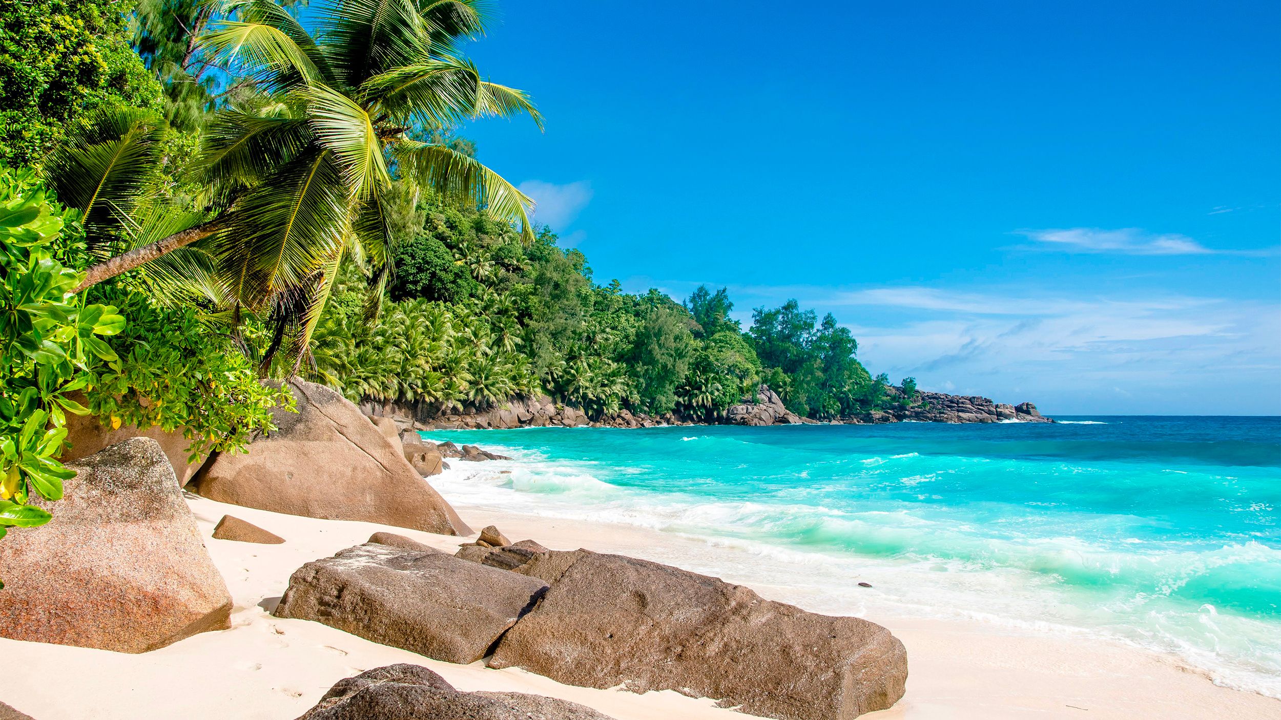 Pláž na Seychelách s charakteristickými žulovými skalami a tyrkysovým morom