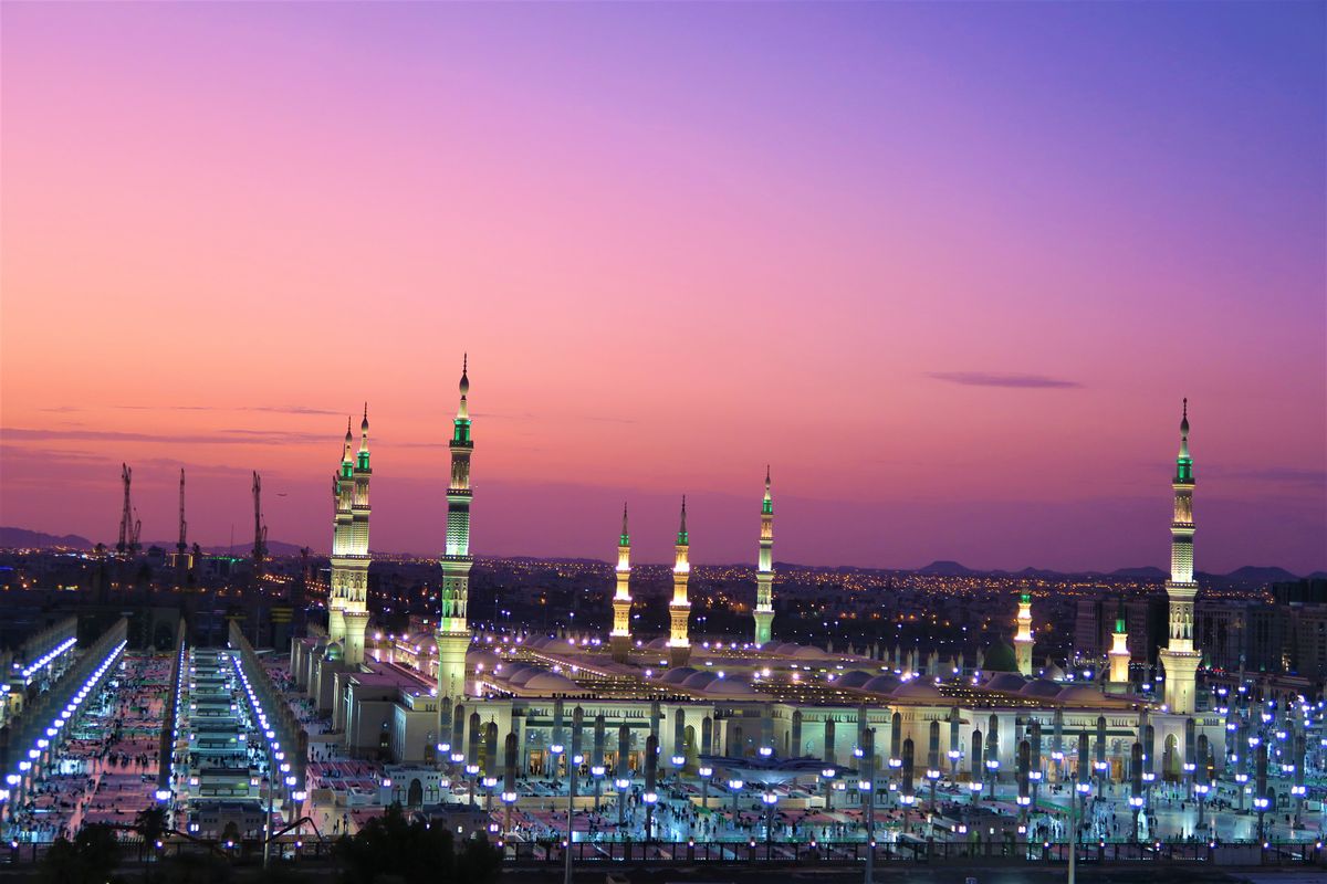Mešita Proroka v Saúdské Arábii při západu slunce, fascinující se svými osvětlenými minarety.