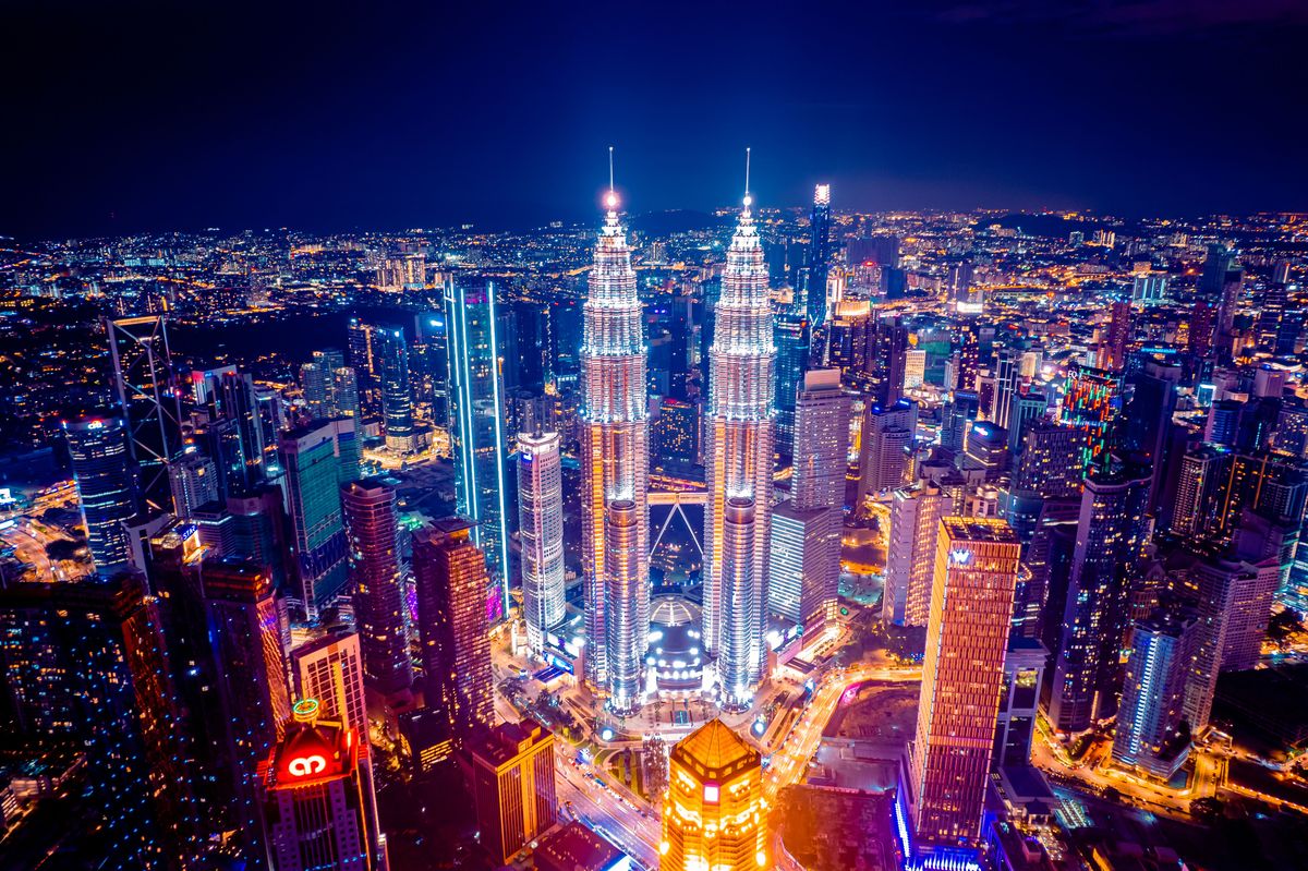 Panorama Kuala Lumpur s ikonickými Petronas Twin Towers a moderní architekturou mostu Saloma Bridge v popředí.