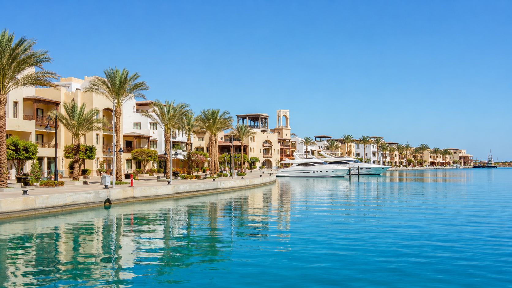 Přístav Port Ghalib v Egyptě s jachtami kotvícími u nábřežní promenády lemované palmami a tradční architekturou