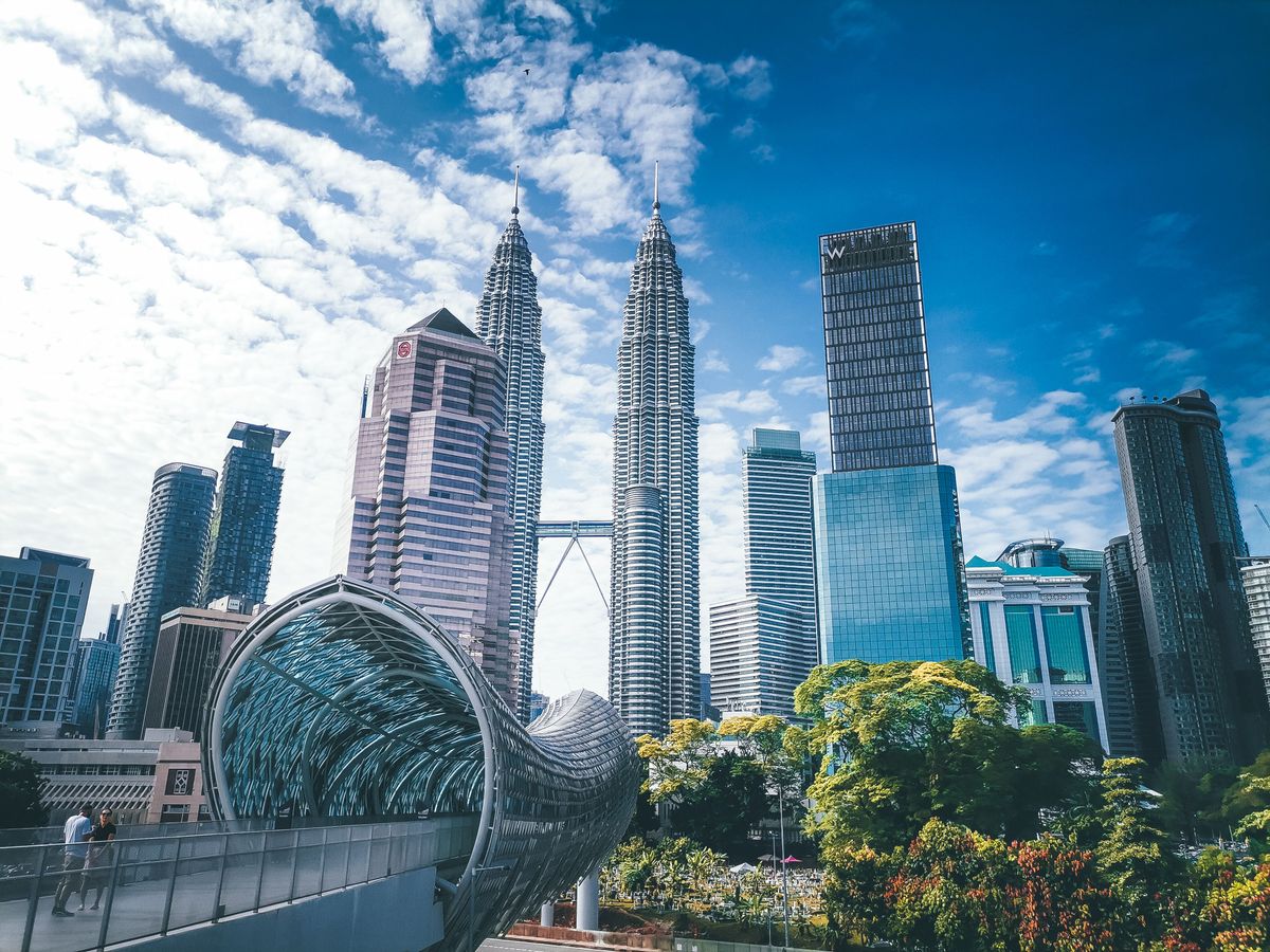 Panorama Kuala Lumpur s ikonickými Petronas Twin Towers a moderní architekturou mostu Saloma Bridge v popředí.