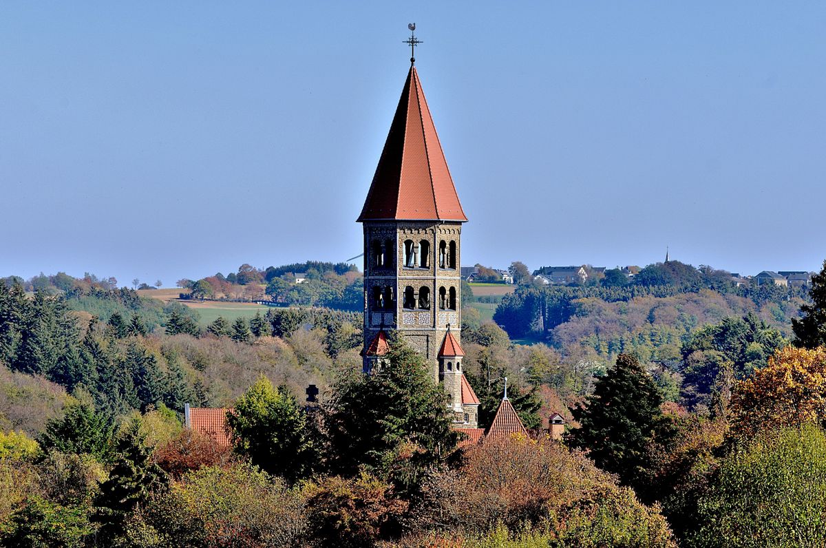 Věž benediktinské opatství ve městě Clervaux se tyčí nad okolní zelení a&nbsp;krajinou.