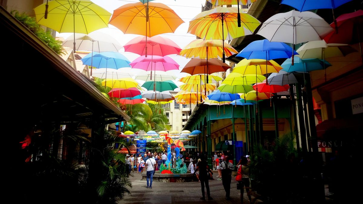 Barevná ulička s deštníky na nábřeží Caudan v Port Louis.